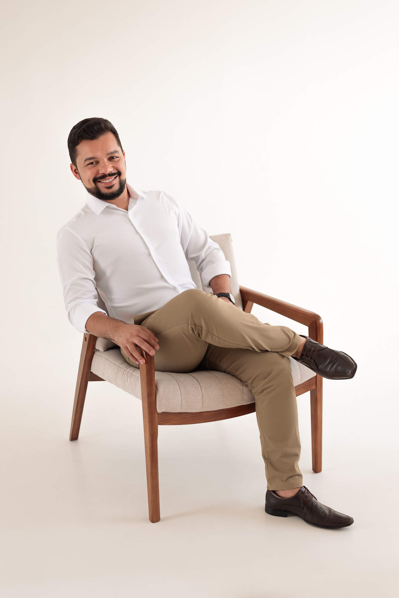 Louis Servilha sentado em uma poltrona, em retrato profissional